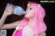 A woman in a pink bikini drinking water from a bottle.