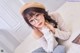 A woman wearing glasses and a beret sitting on a bed.