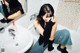 A woman sitting in a bathroom next to a sink.
